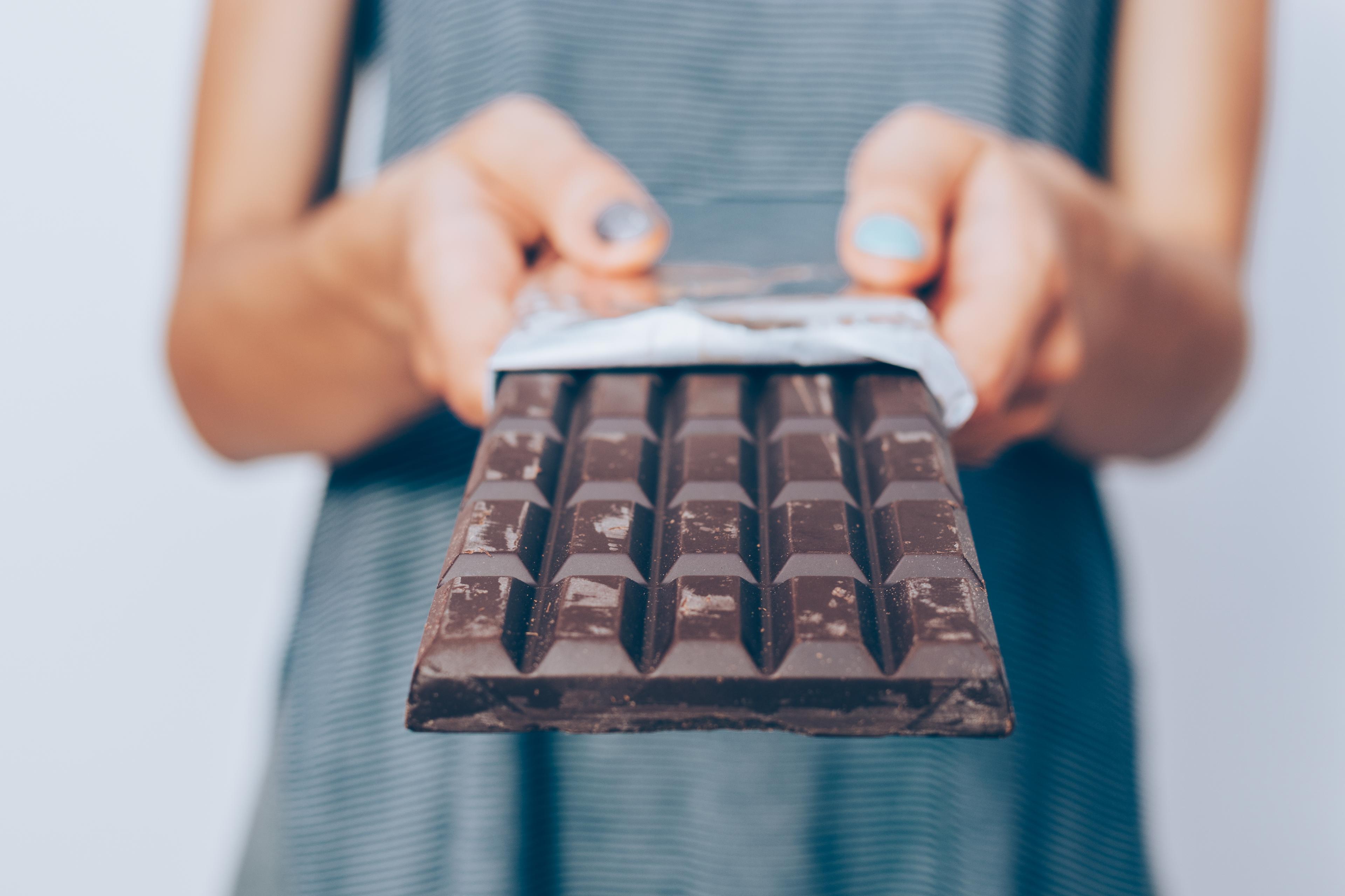 benefits-of-dark-chocolate-woman-holding-unwrapped-chocolate-bar.jpeg